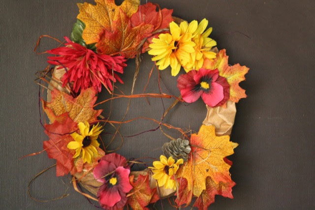 A wreath made from paper bags and plastic flowers.